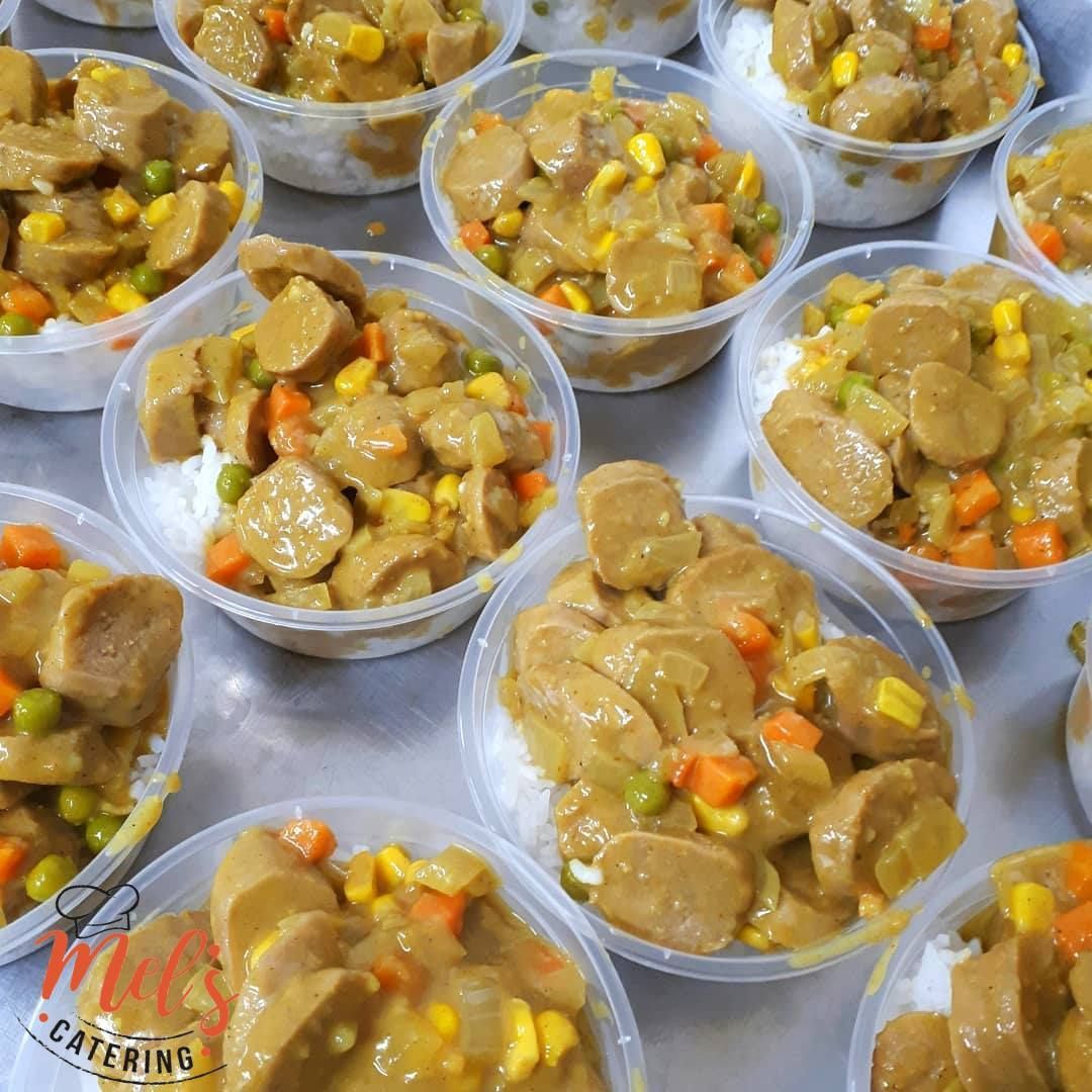 Bowls of food: rice topped with sausage and vegetables in a curry sauce.— Mels Catering in Garbutt, QLD
