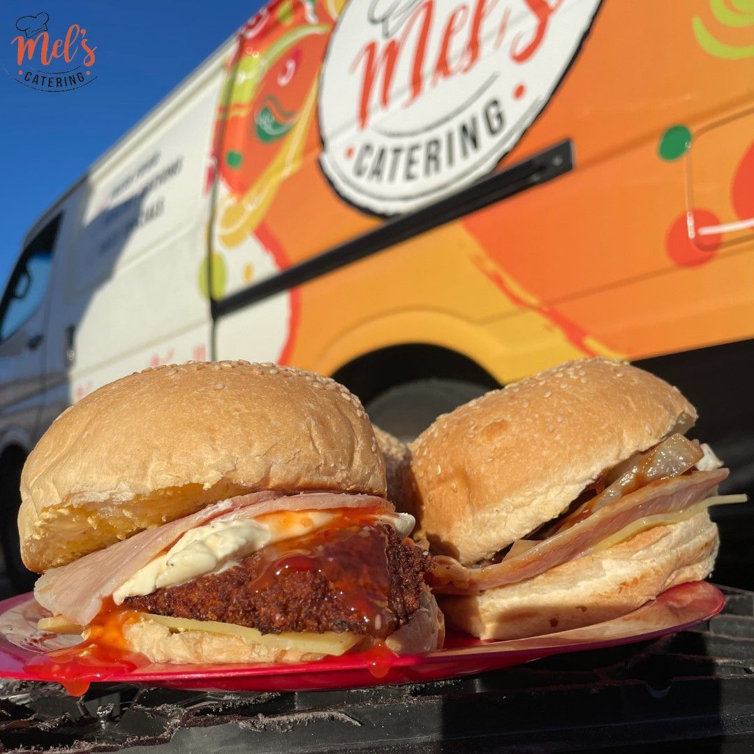 Two Sandwiches On A Red Plate In Front Of A Catering Van — Mels Catering in Garbutt, QLD