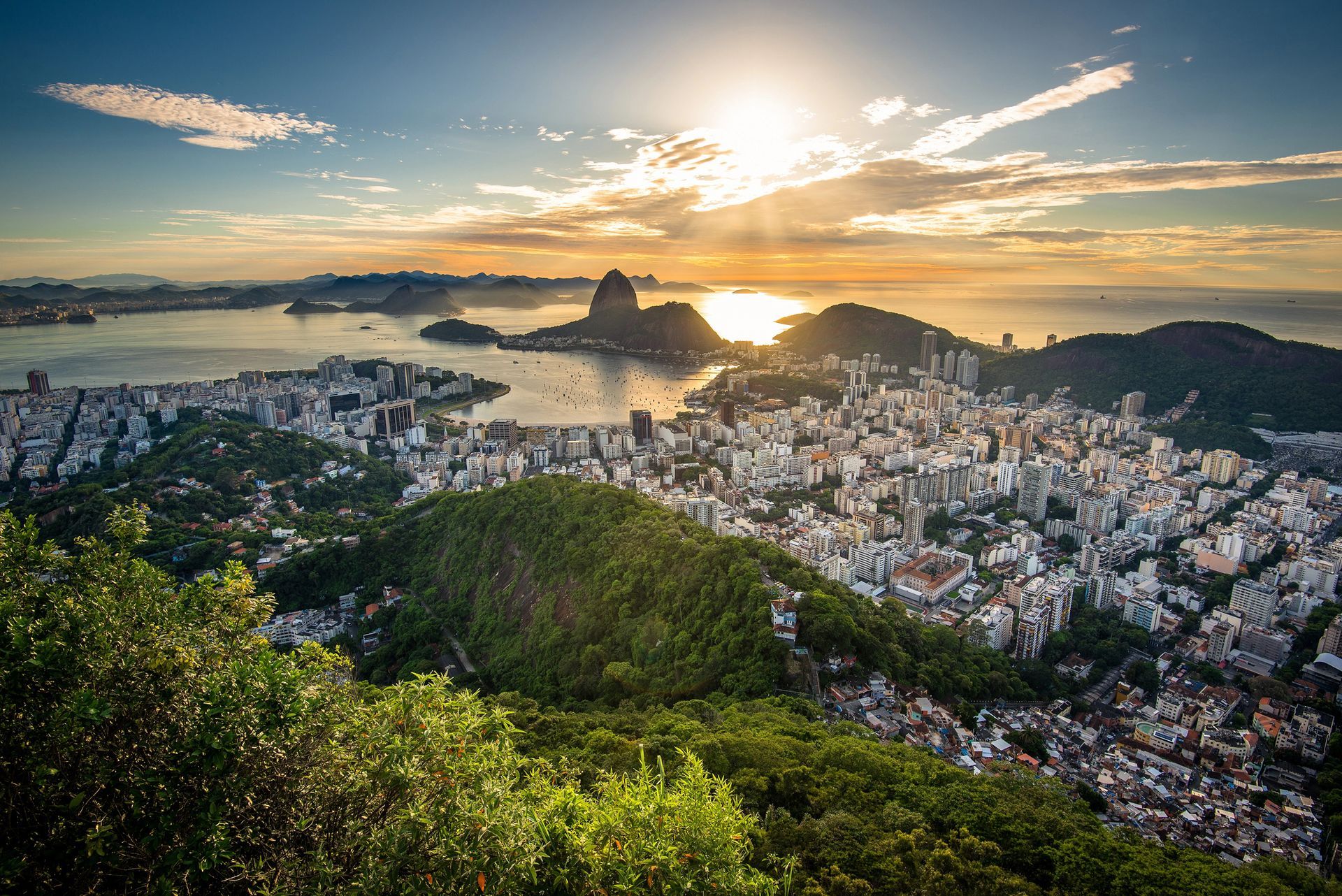 Paisaje urbano de Río de Janeiro al atardecer, con el Pan de Azúcar y la Bahía de Guanabara.