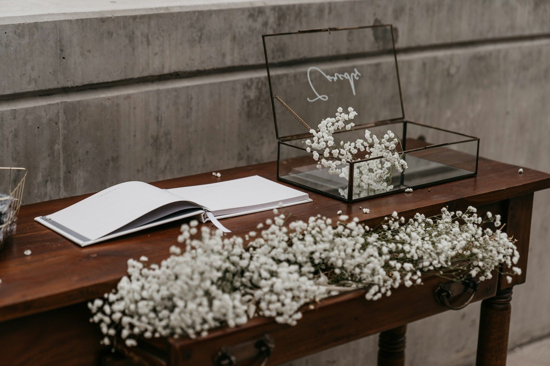 Wedding reception table with guest book, card box, and baby's breath flowers.