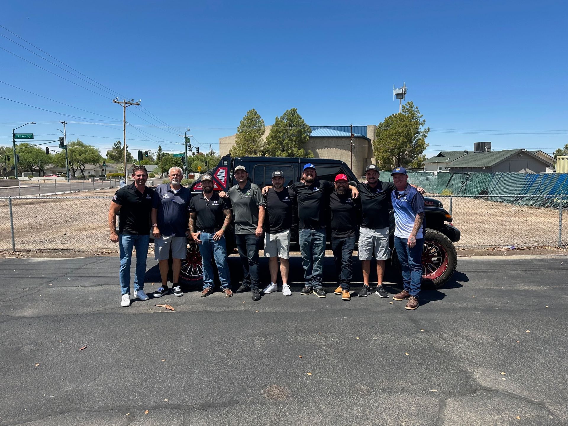 A group of men are posing for a picture in front of a truck.
