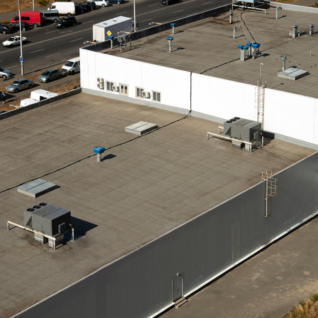 An aerial view of the roof of a building with a fence around it