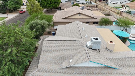 An aerial view of a house with a roof and a pool.