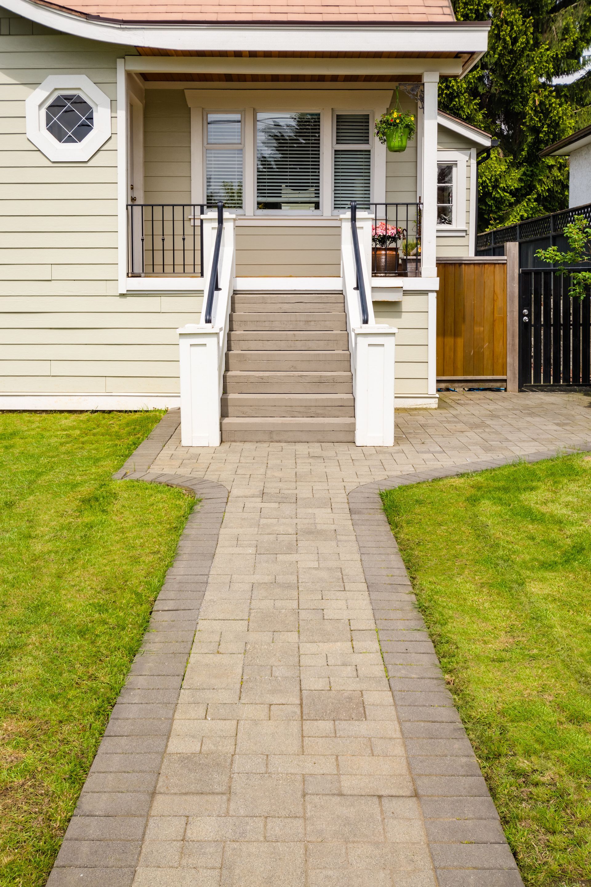A brick walkway leading to the front of a house.