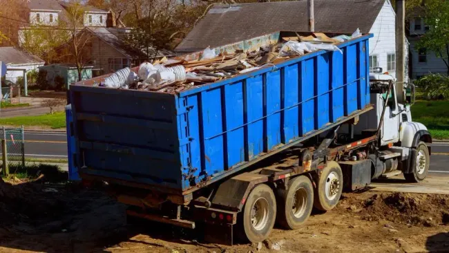 massive construction and landfills carried on truck with blue dumpster on it