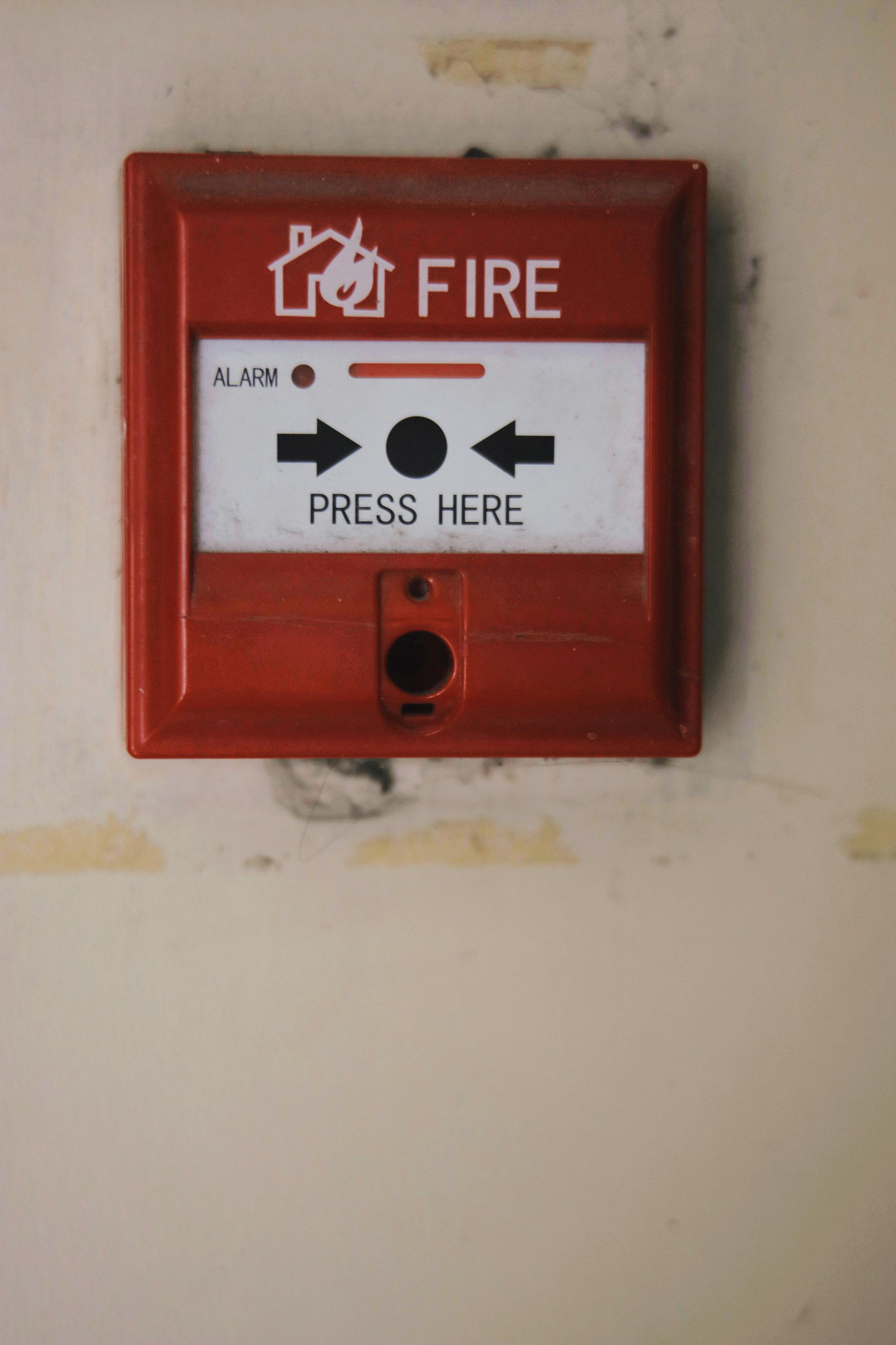 Red fire alarm box on a wall with