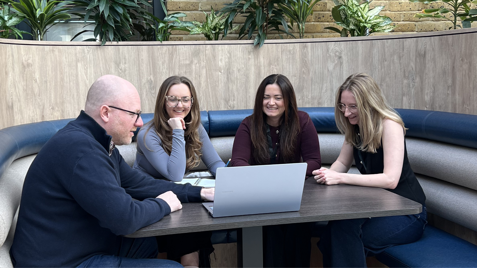 Person typing on laptop, holding phone, search bar overlay.