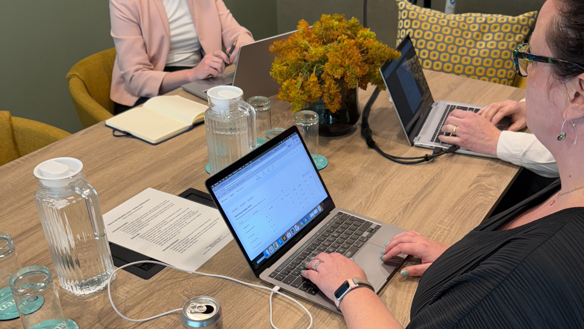 Person typing on laptop, holding phone, search bar overlay.