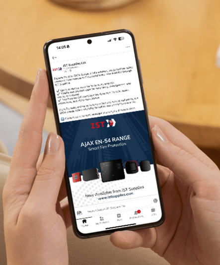 Person holding a phone displaying a social media post for AJAX ON-S4 security products.