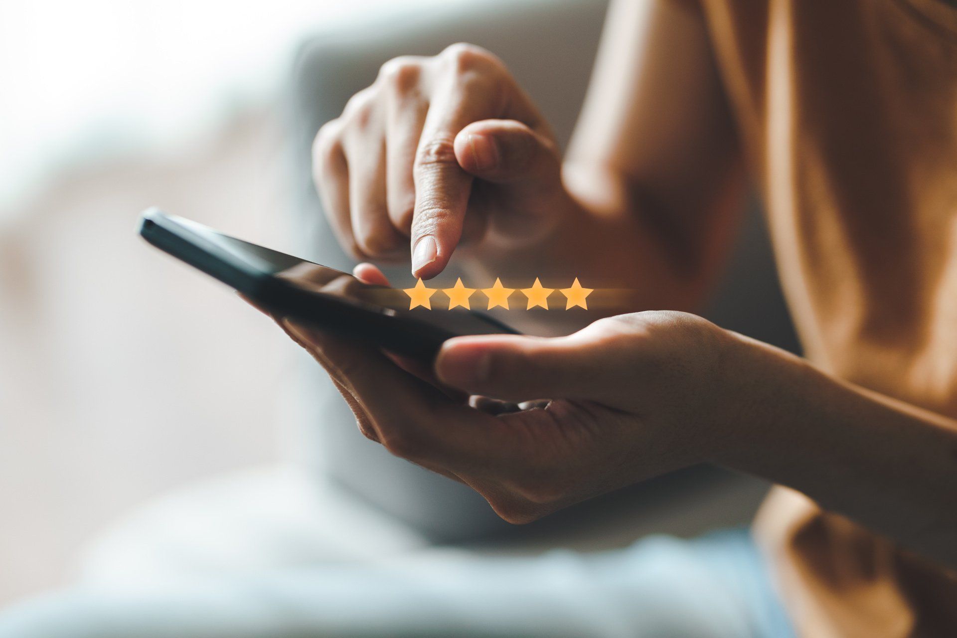 Woman's hands leaving 5 star review on phone