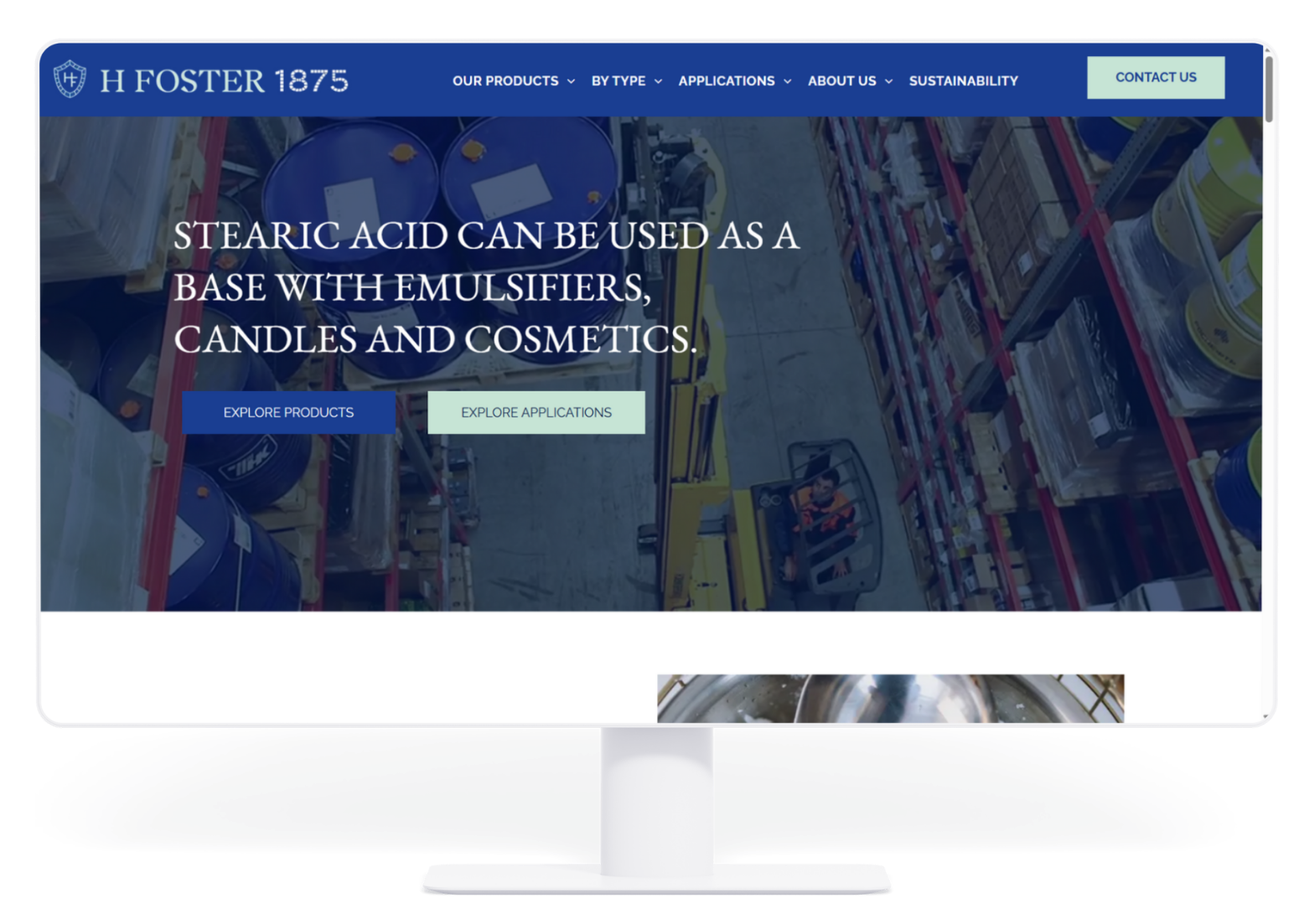 A computer monitor displays a website for H. Foster 1875 featuring stearic acid product information over a warehouse view.