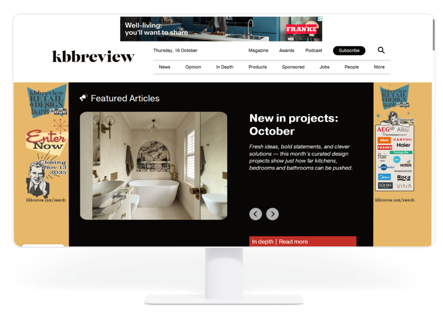 A computer monitor displaying the kbbreview website home page with a featured article about bathroom design projects.