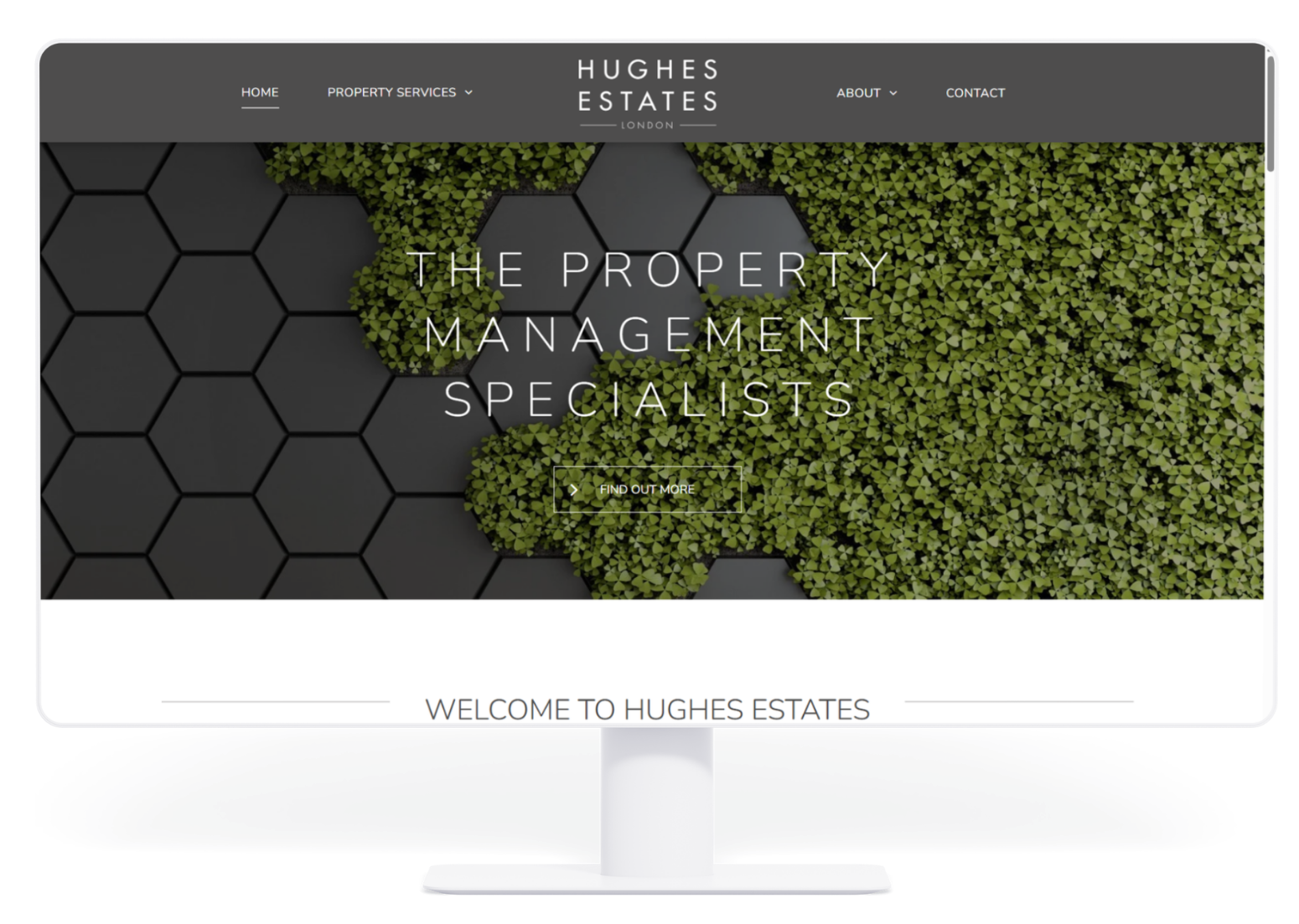 A computer monitor displaying the Hughes Estates website, featuring a header with a green foliage and black hexagon design.