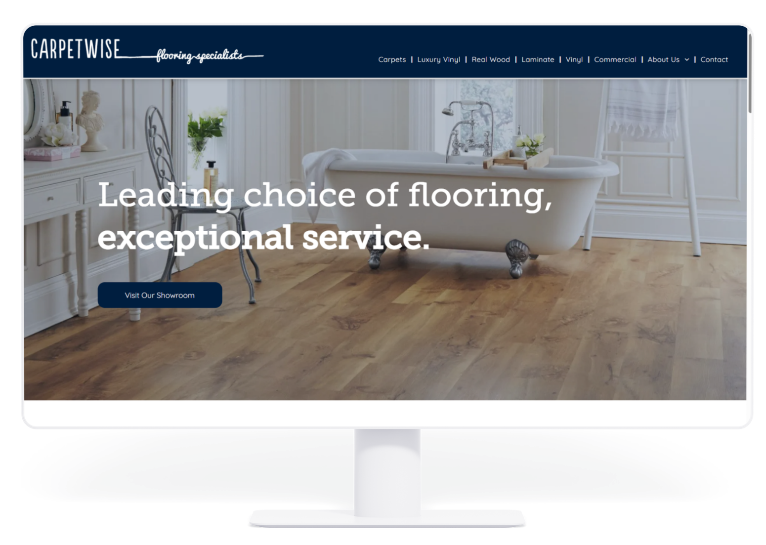 A desktop monitor displaying the Carpetwise website homepage, featuring a bathroom interior with wood-look flooring.