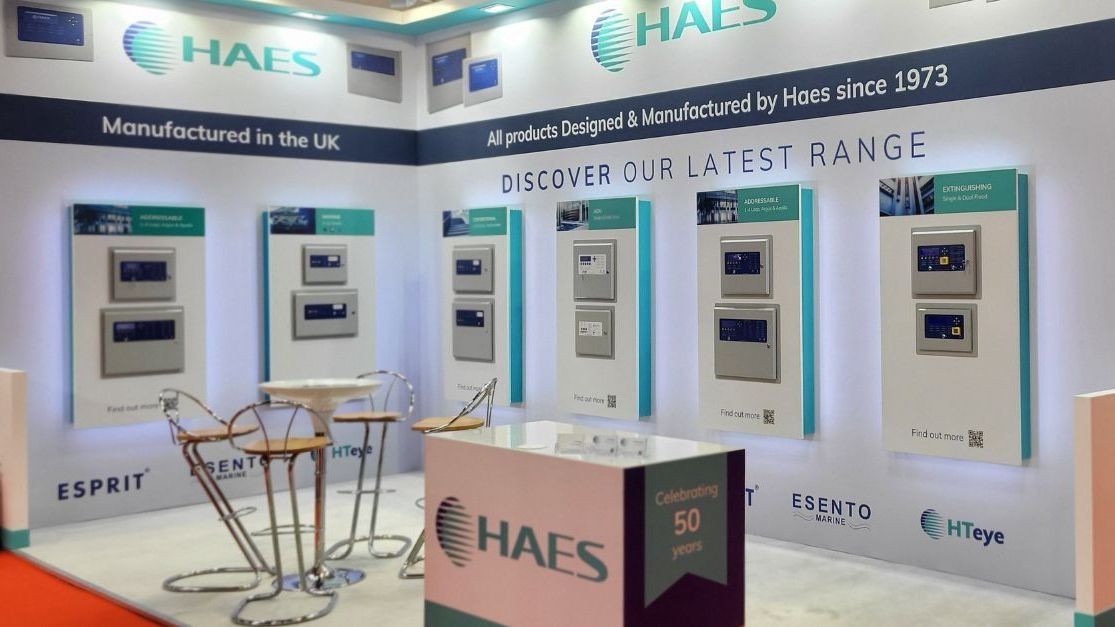 A haes booth with a table and chairs in front of it