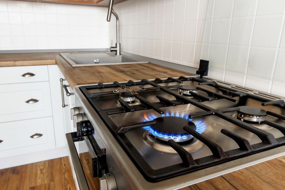 Gas Stove With Blue Flame Lit in a Kitchen Setting — Stewys in Casuarina, NSW