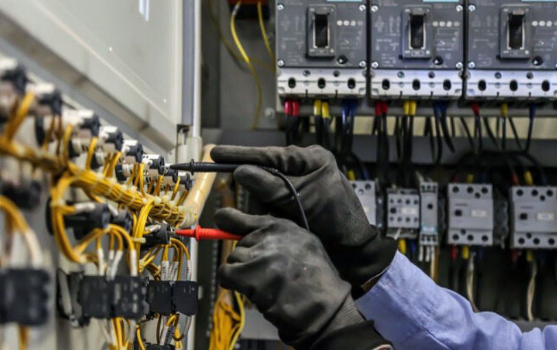 A Man is Working on an Electrical Box With a Screwdriver — Stewys Electrical and Communications In Casuarina, NSW