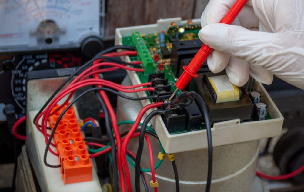 A Person is Using a Multimeter to Test a Circuit Board — Stewys Electrical and Communications In Casuarina, NSW