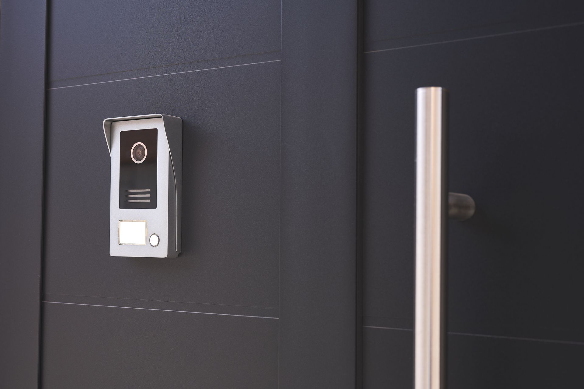 Gray Intercom On A Dark Gray Door Next To A Silver Handle — Stewys Electrical and Communications In Tweed Heads, NSW