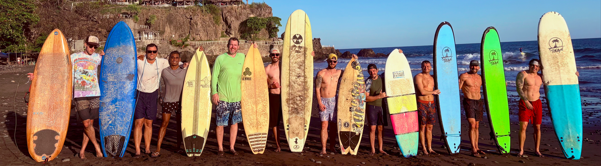 A group of people holding surfboards on a beach