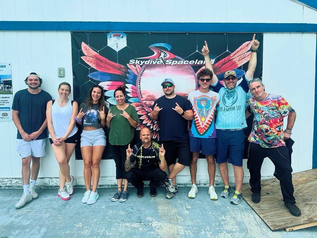 A group of people are posing for a picture in front of a building.