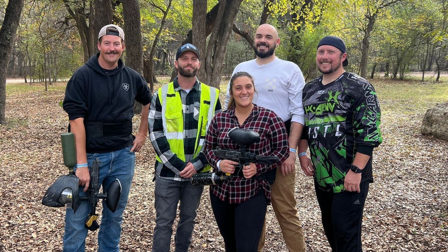 A group of people are posing for a picture in the woods.