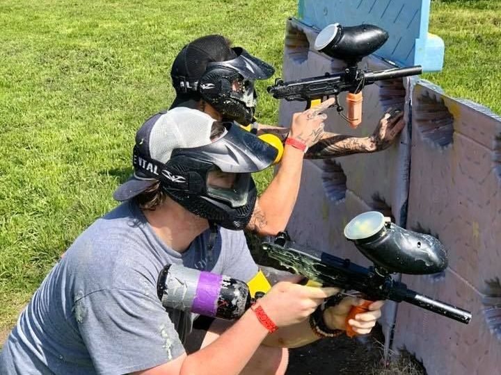 A group of people are playing paintball in a field.