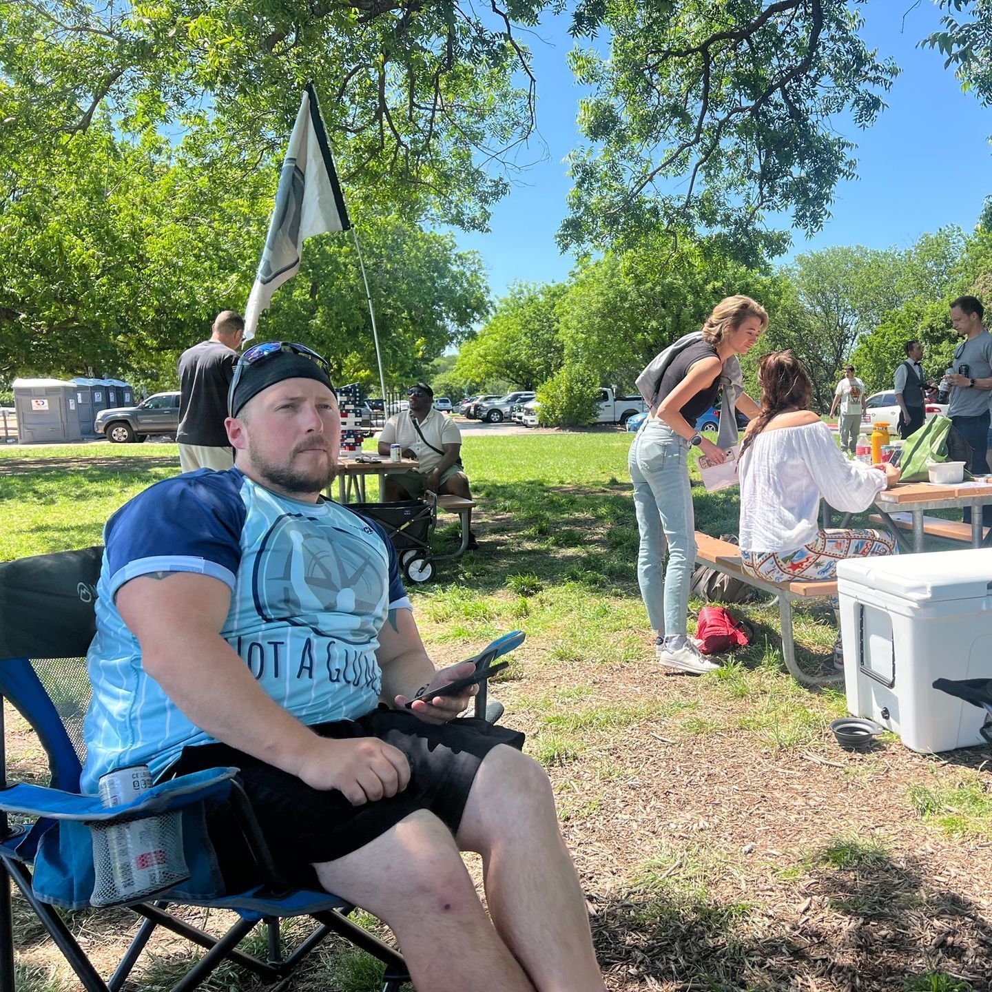 A man is sitting in a chair in a park.