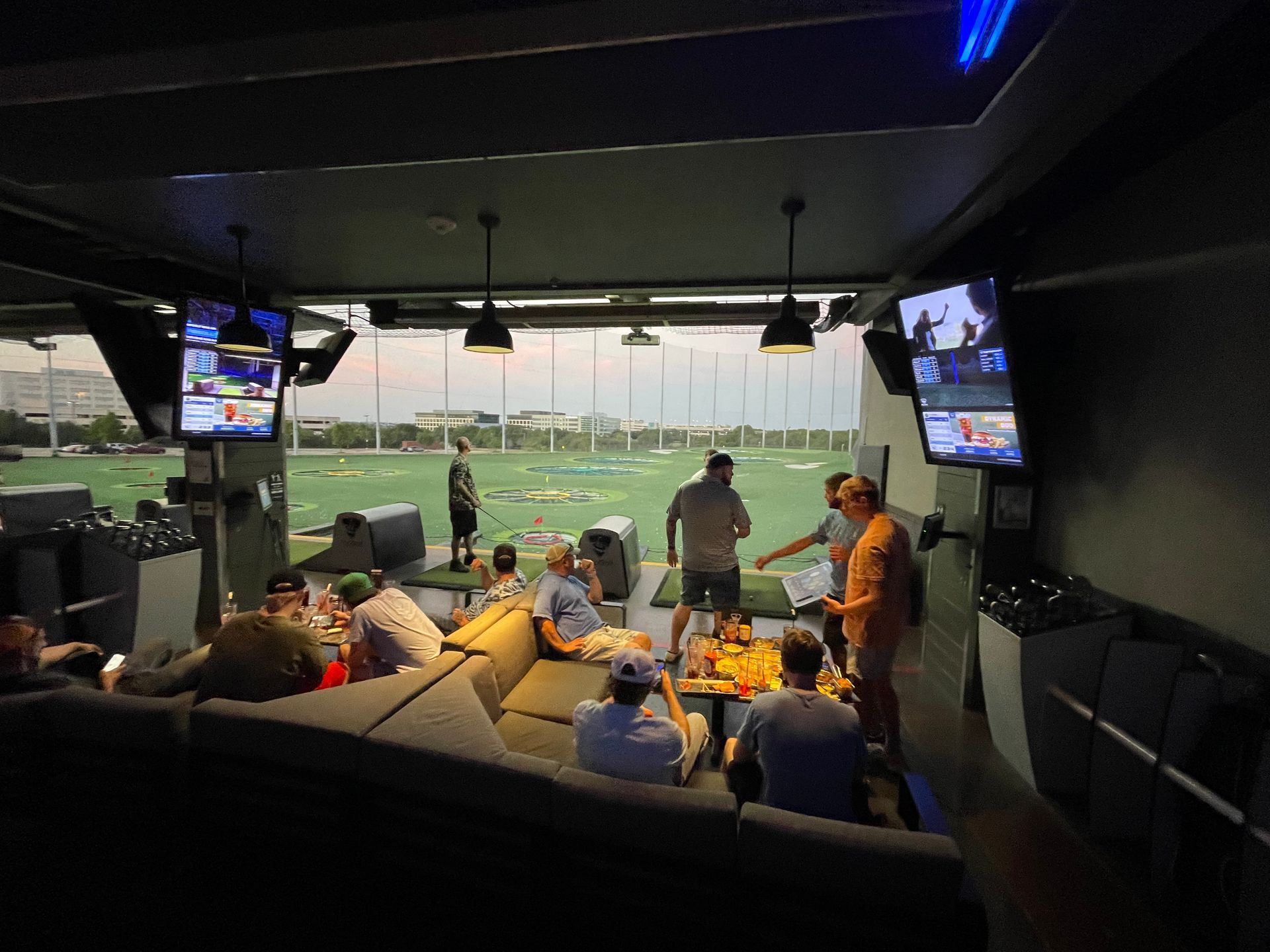 A group of people are eating pizza in a park.