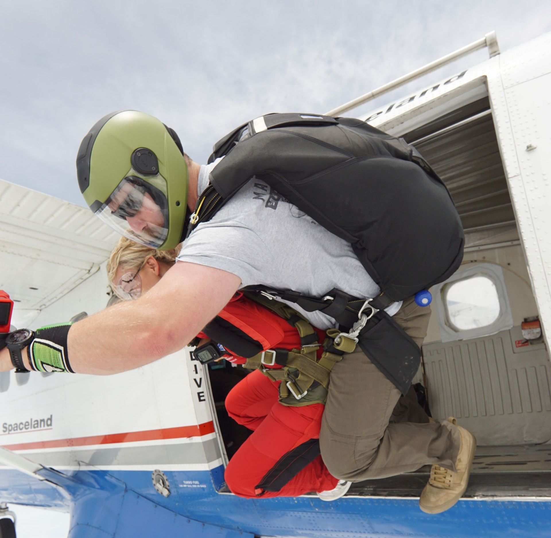 A man is jumping out of a plane with the word live on the side
