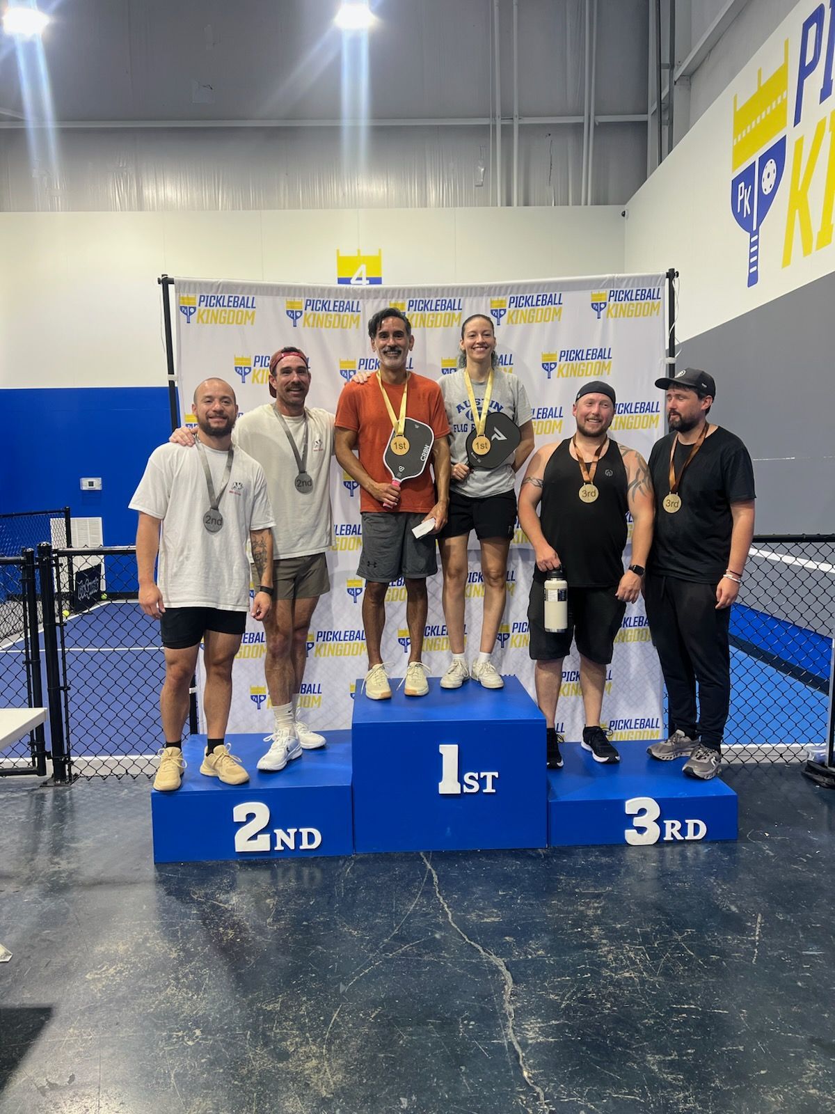 A group of people are standing on a podium in a gym.