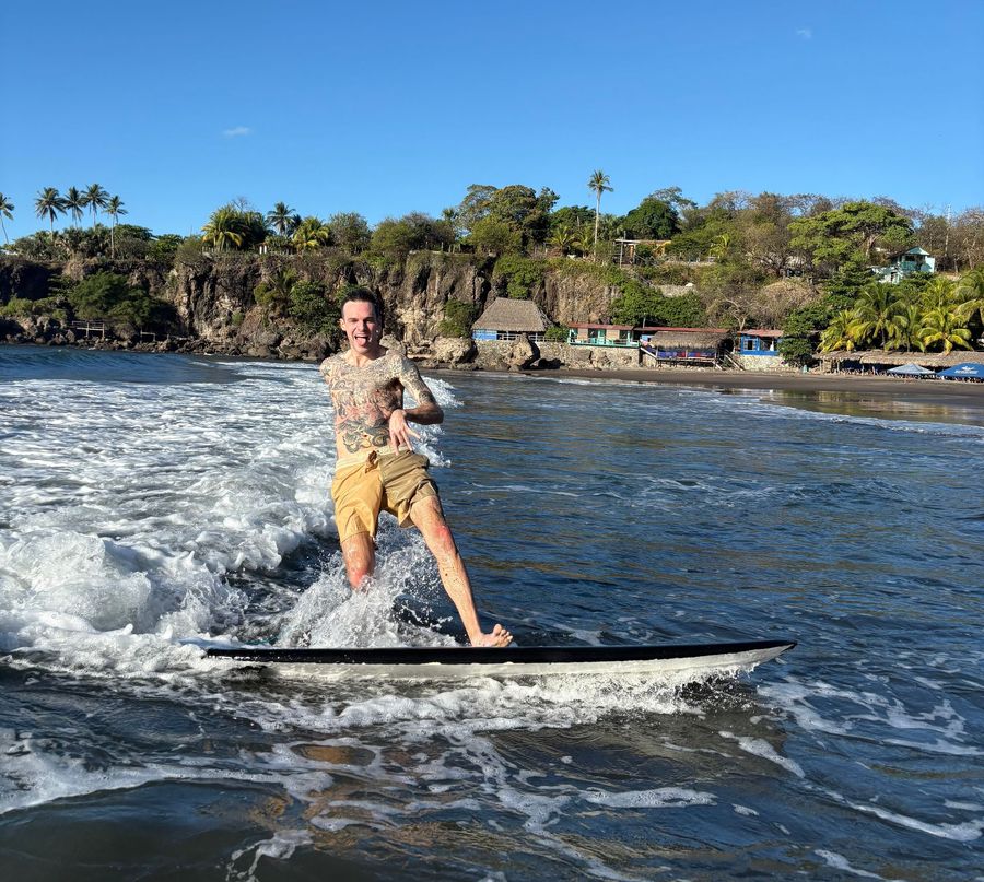 A man is riding a wave on a surfboard in the ocean.