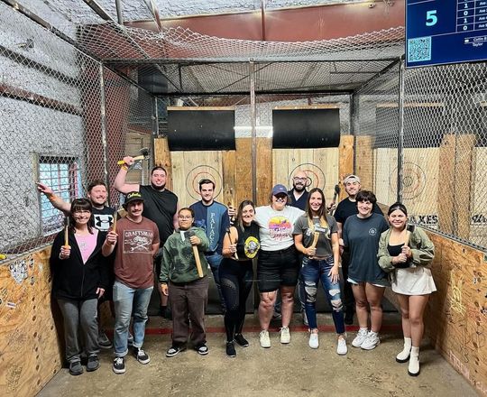 A group of people are standing on top of a boat in the water.