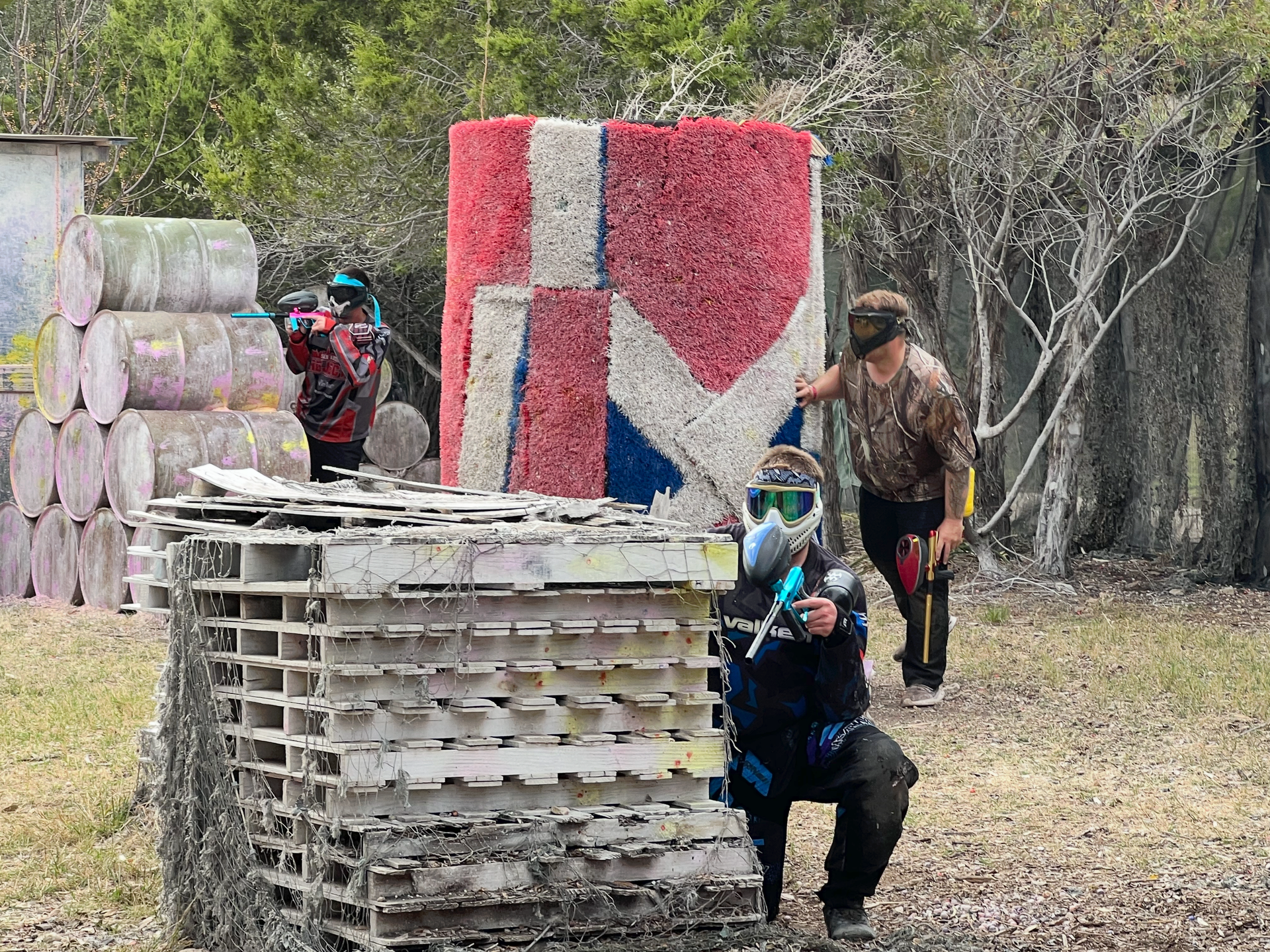 A group of people are playing paintball in a field.