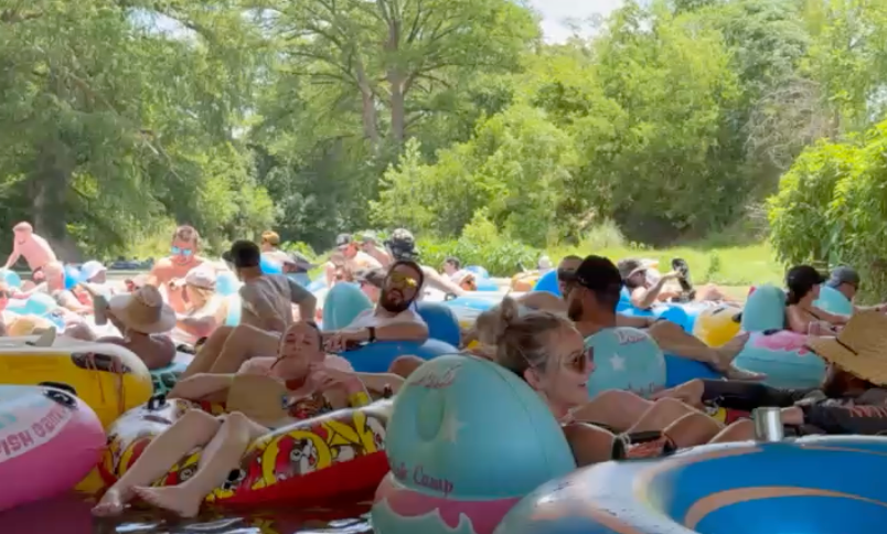 Two men are playing a game at a picnic table in a park.