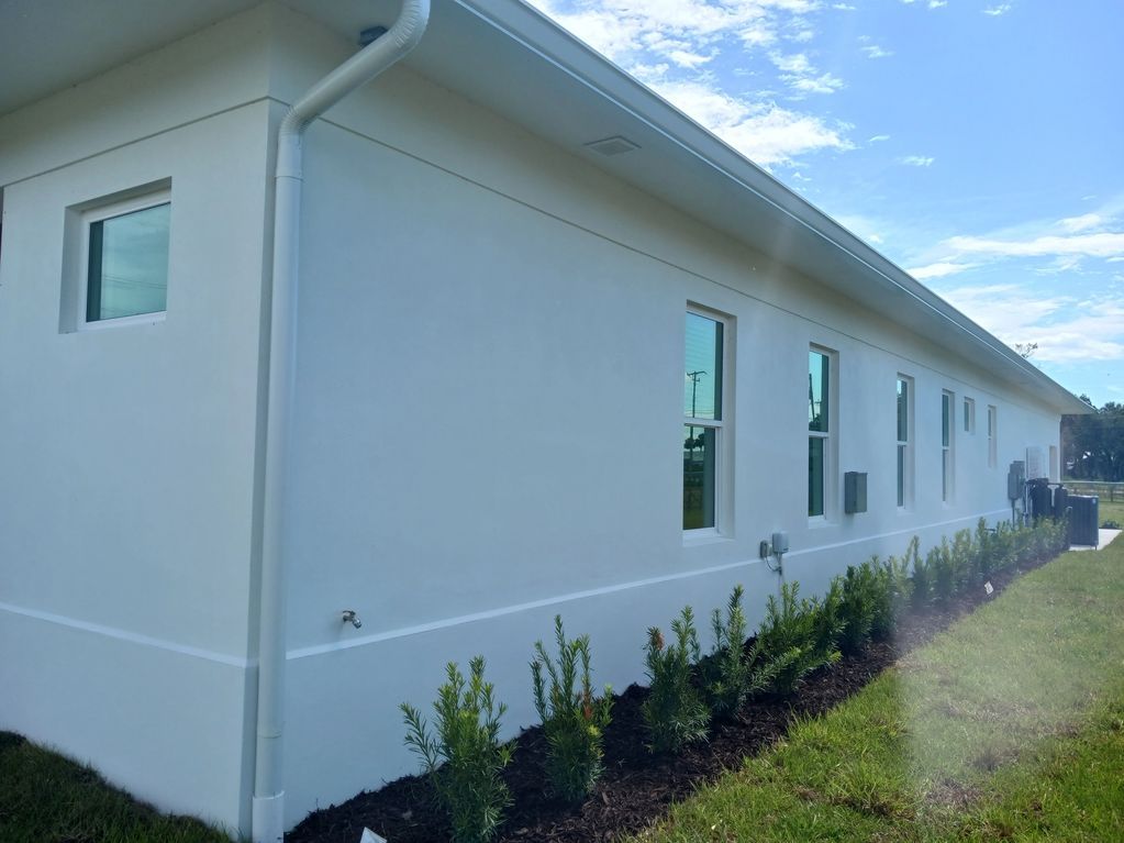 A white house with a lot of windows and a gutter