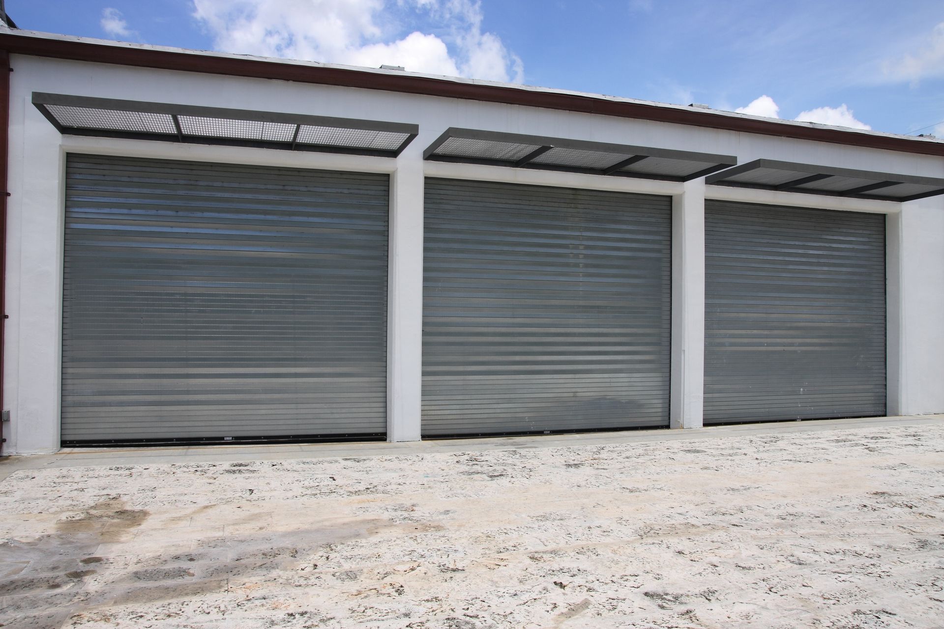 A row of garage doors with a canopy over them.