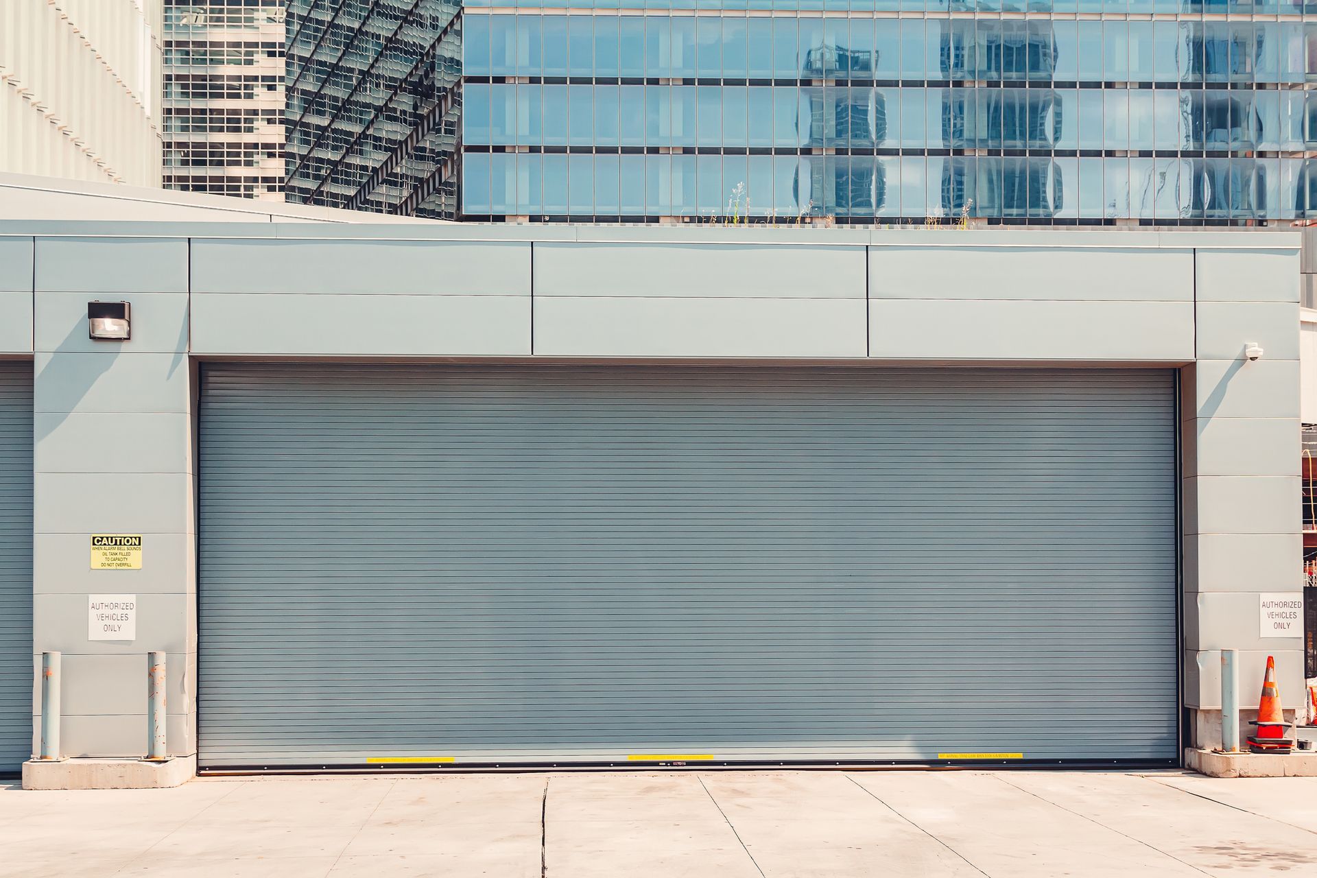 A gray garage door is open in front of a building.