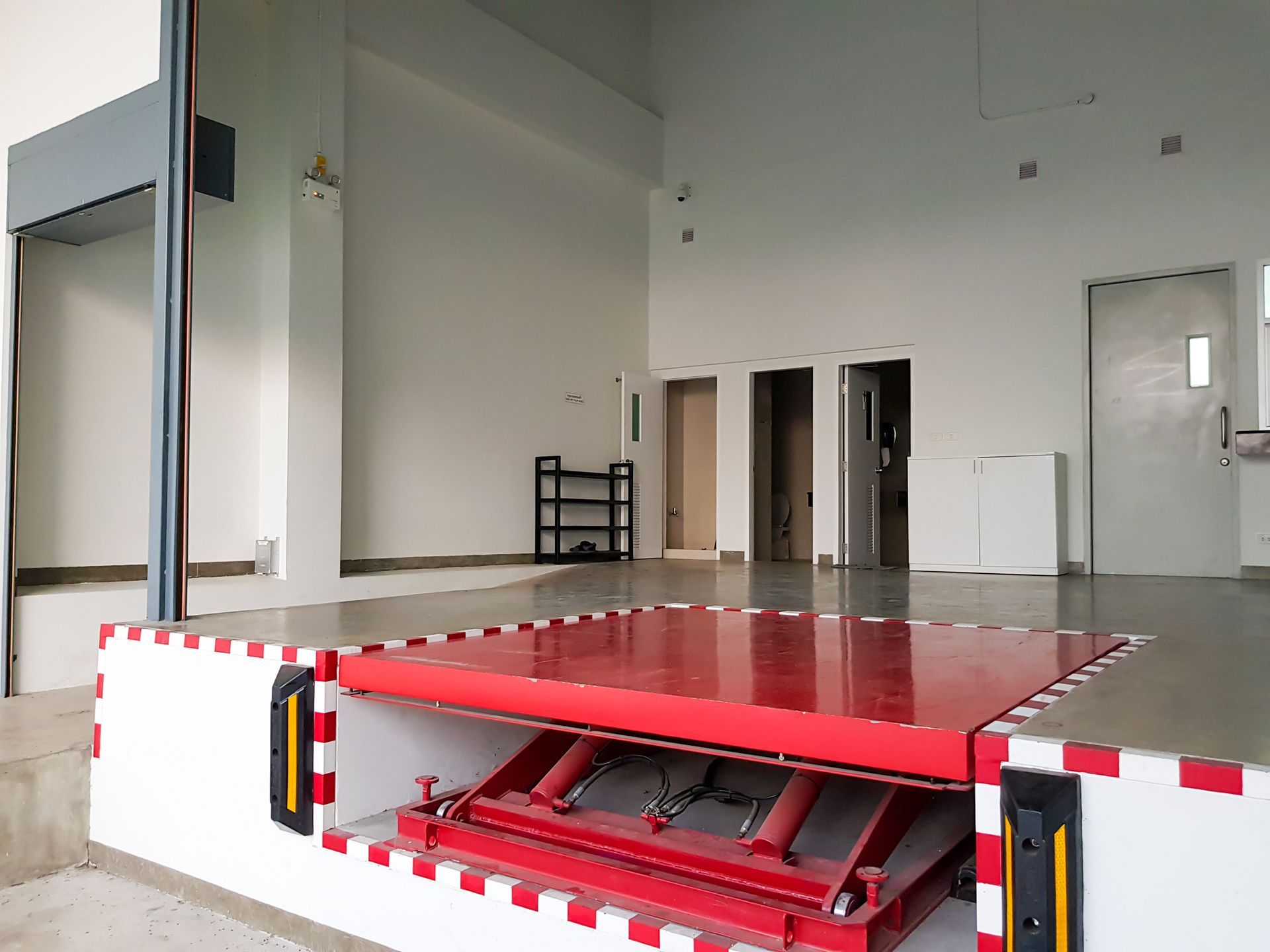 An empty room with a red lift in the middle.
