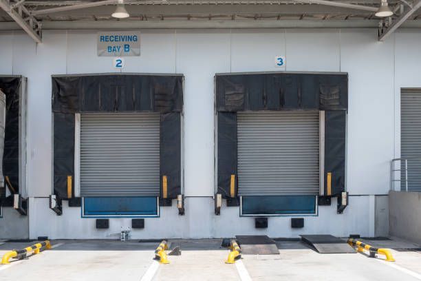 A warehouse with numerous loading docks and a sign.
