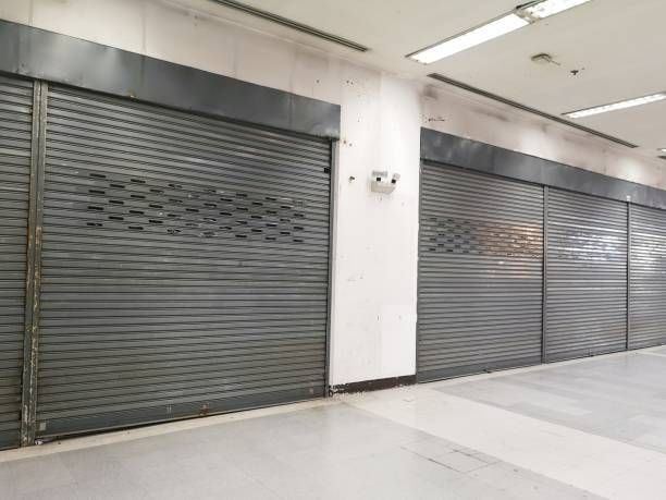 A row of closed garage doors in an empty building.