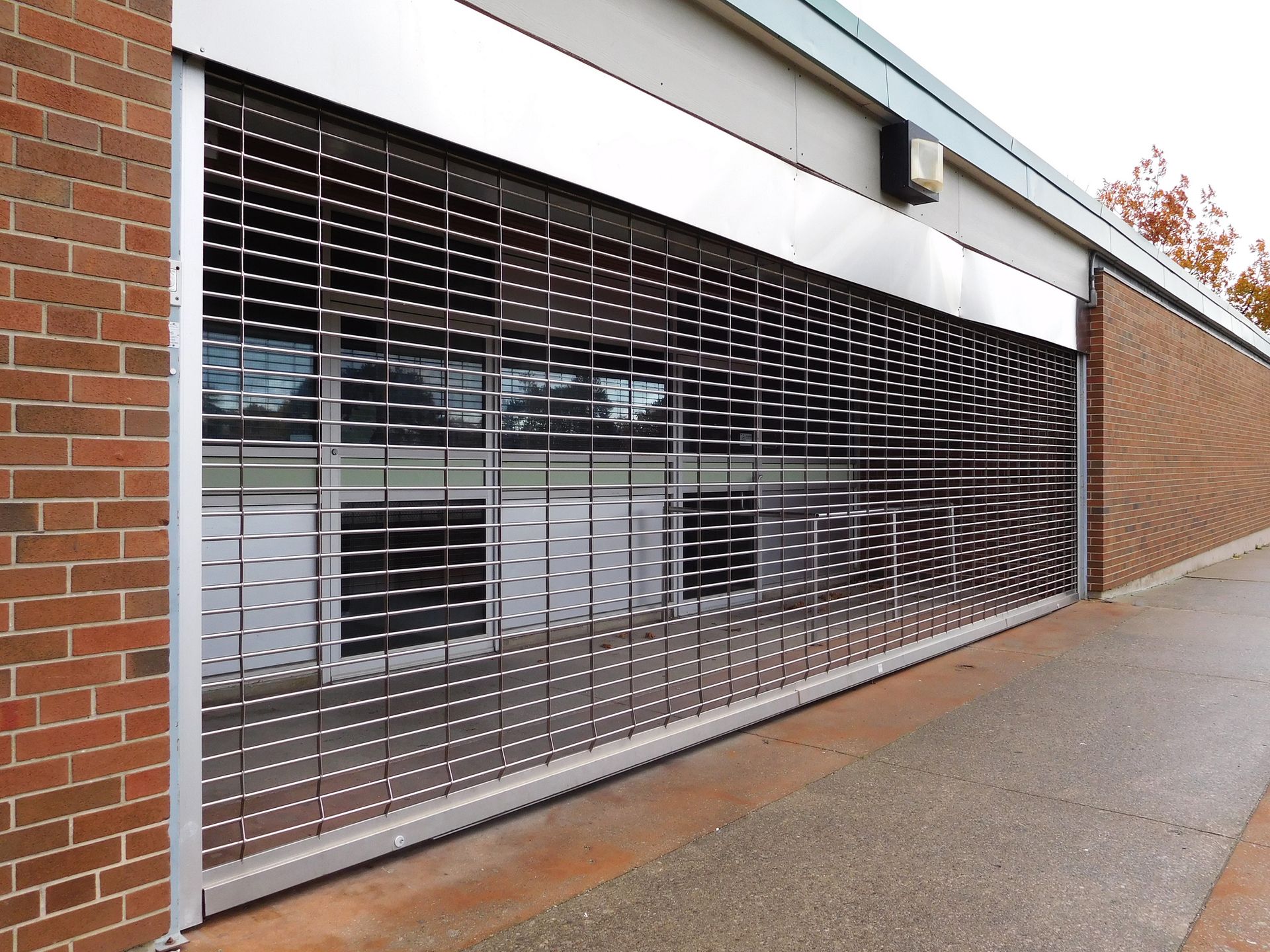 A white fence is sitting in front of a large building.