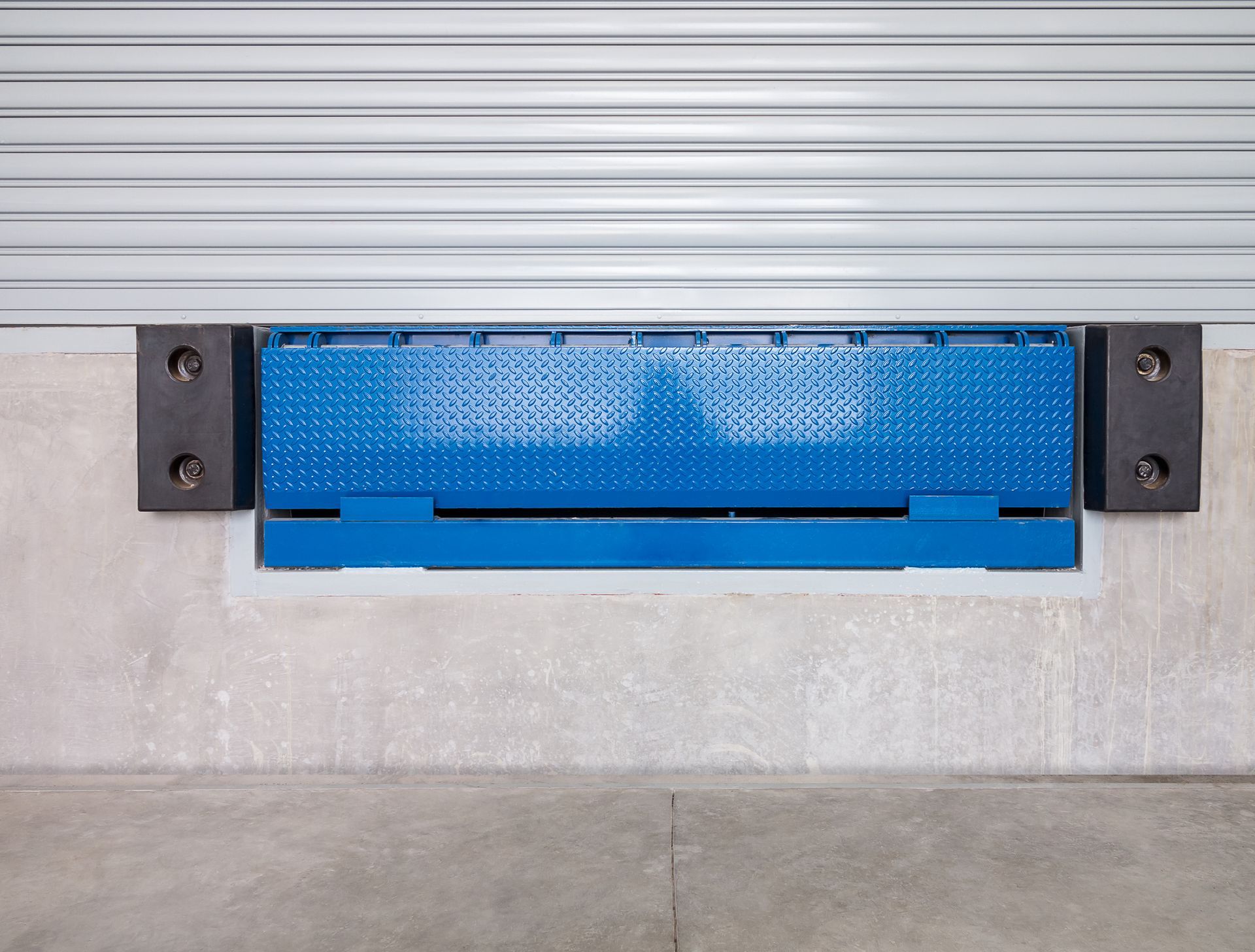 A blue dock ramp is attached to the side of a building.