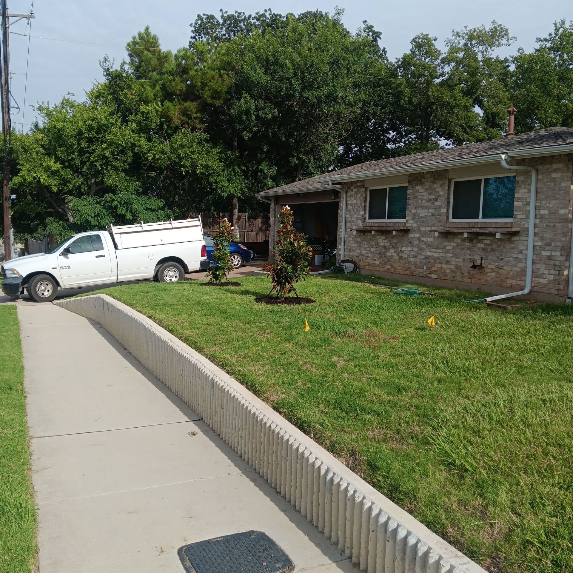 A white truck is parked in front of a brick house