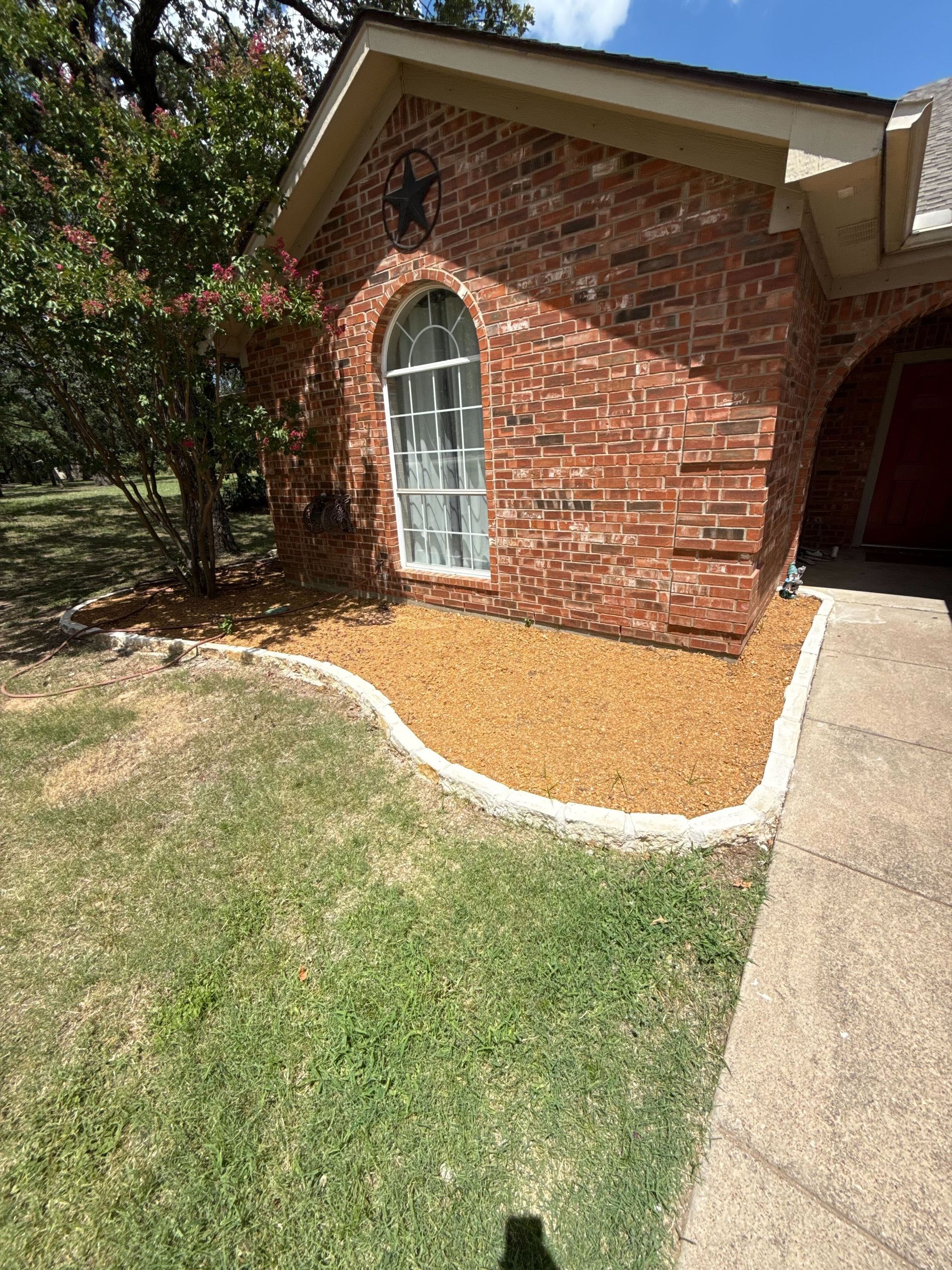 A brick house with a lush green lawn in front of it.