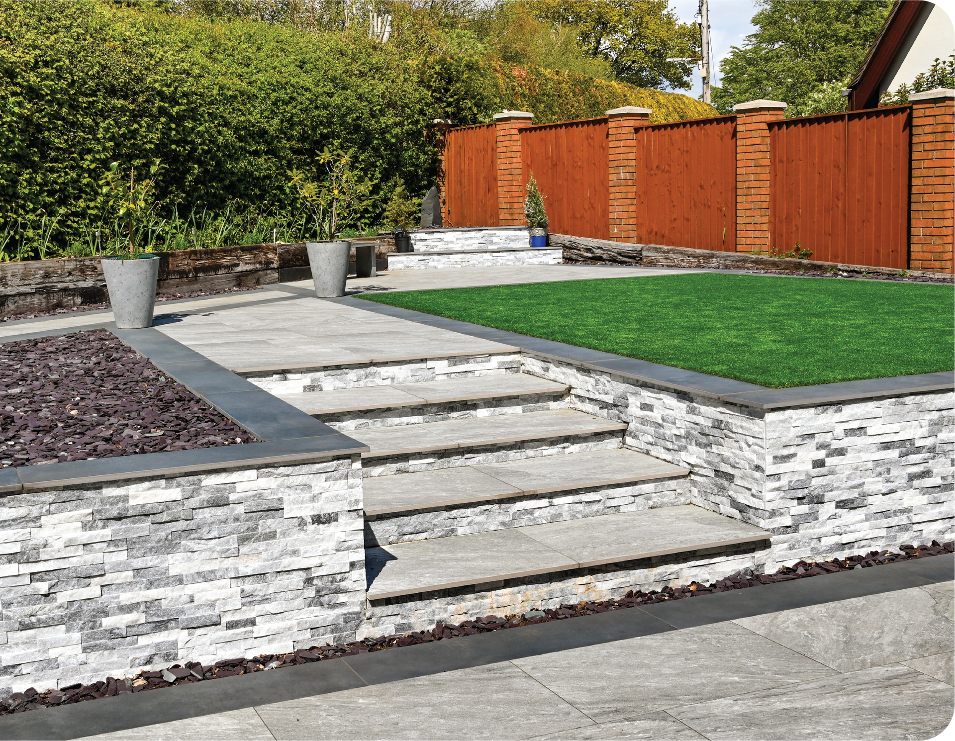 A stone wall with steps leading up to a grassy area