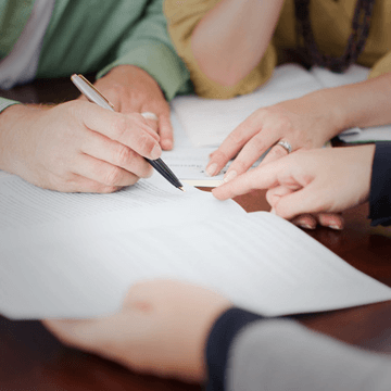 a group of associates discussing over a document