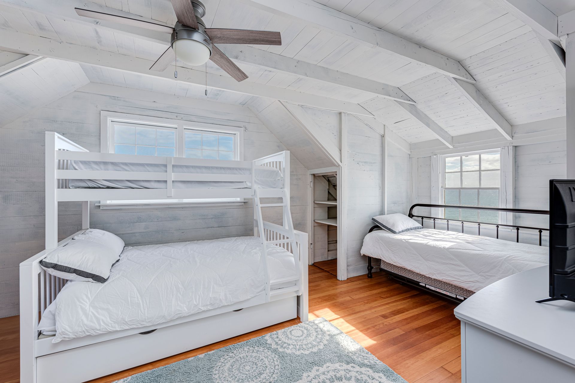 A bedroom with two bunk beds and a ceiling fan.