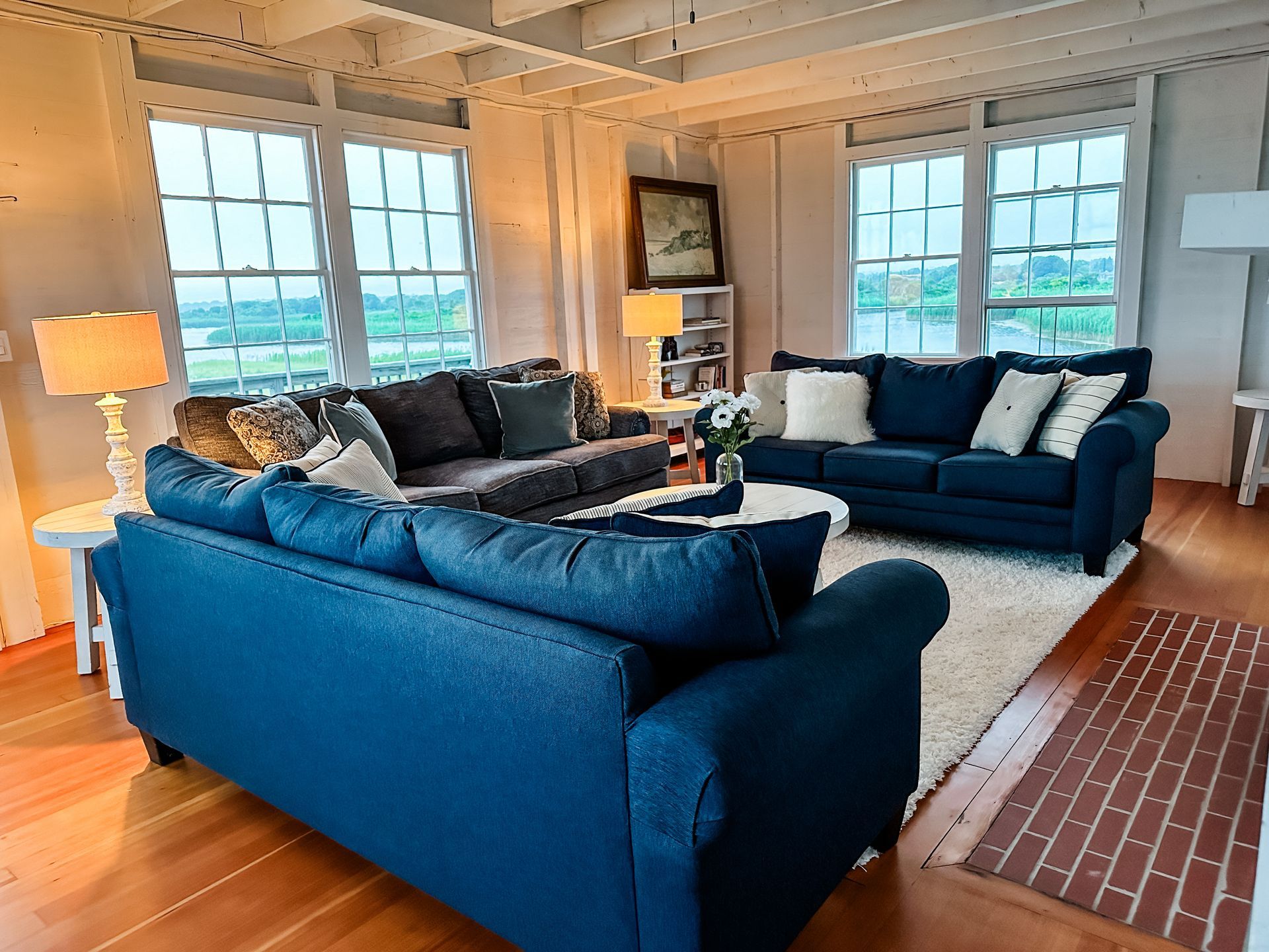A living room with two blue couches and a rug