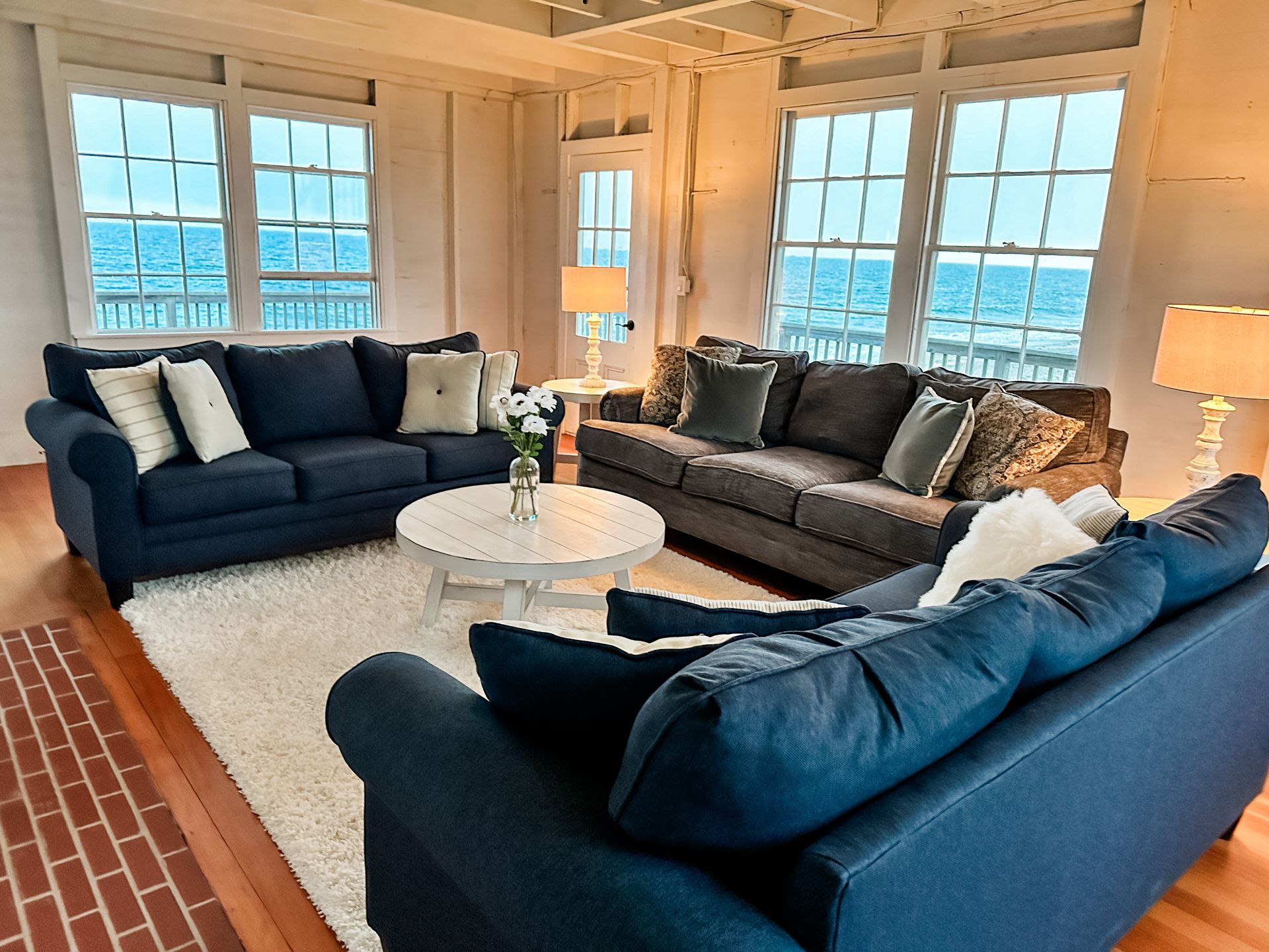 A living room with blue couches and a white rug
